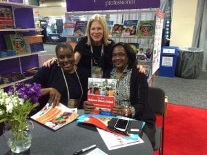 Dr. Margaret Policastro with two educators holding books