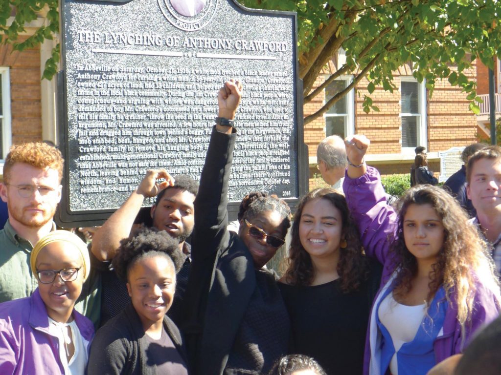 Doria Johnson (center, arm raised) celebrates unveiling of Anthony Crawford marker