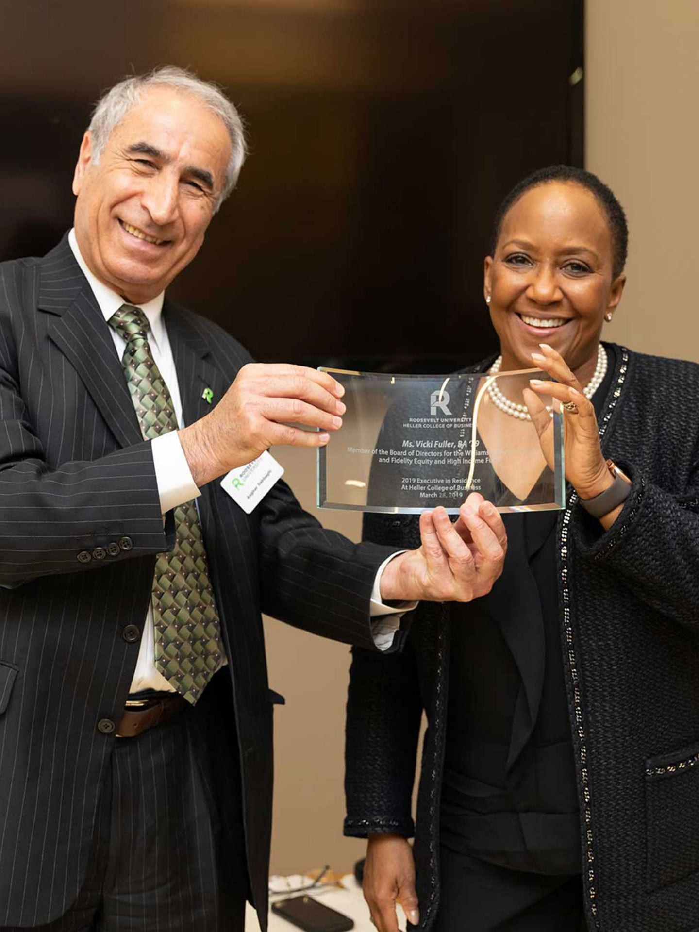 During Vicki Fuller's visit to Roosevelt University, Heller College of Business Dean Asghar Sabbaghi presented her with an award recognizing her storied career and contributions.